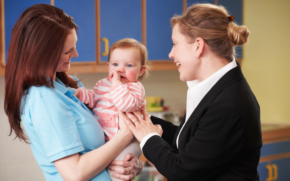 Bébé dans les bras d'accueillantes